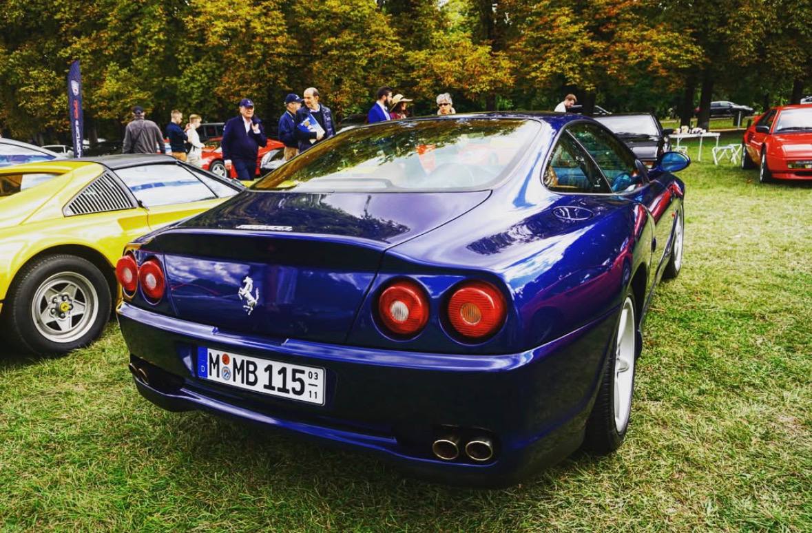 A blue Ferrari photographed at an outdoor collector car gathering